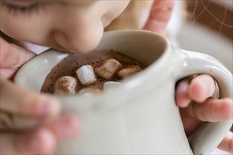 Girl drinking hot chocolate with marshmallows