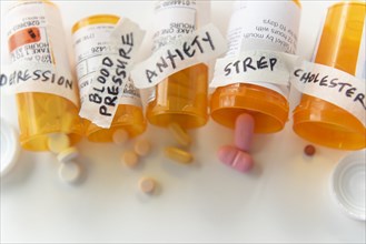 Spilled pill bottles labelled with ailments
