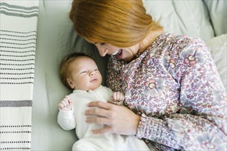 Mother lying on bed with her newborn son