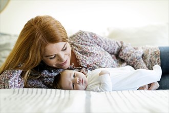 Mother lying on bed with her newborn son