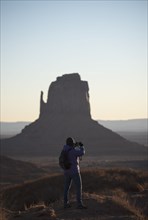 Woman photographing Monument Valley in Arizona, USA
