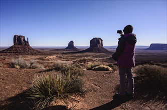 Woman photographing Monument Valley in Arizona, USA