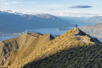 Man standing on mountain peak by Lake Wanaka, New Zealand