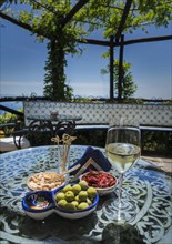 Antipasto and wine on dining table under pergola