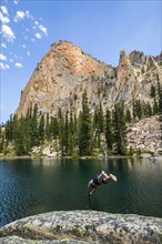 Man diving into lake by mountain in Stanley, Idaho, USA