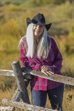 Mature woman wearing cowboy hat in field