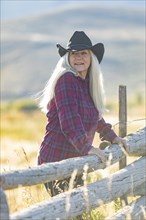 Mature woman wearing cowboy hat in field