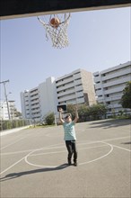 Teenage ball shooting basketball