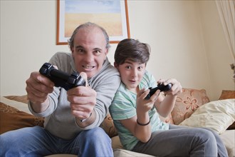 Father and teenage son playing video game