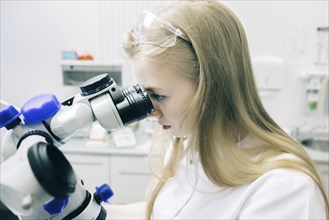 Young woman using microscope