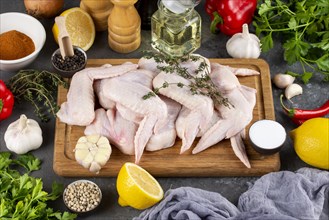 Raw chicken on cutting board surrounded by ingredients
