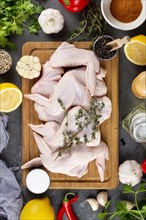 Raw chicken on cutting board surrounded by ingredients