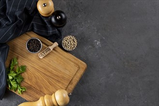 Pepper and pepper mills on cutting board