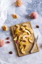 Peaches sliced on wooden cutting board