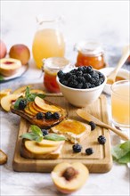 Breakfast spread with blackberries, peaches, toast and apricot jam