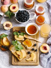 Breakfast spread with blackberries, peaches, toast and apricot jam