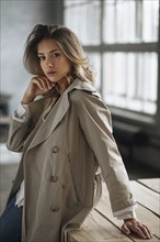 Young woman wearing grey trench coat
