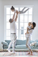 Parent lifting daughters by window