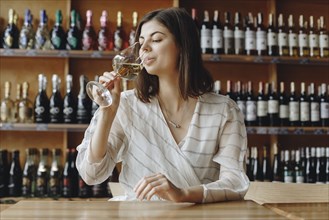 Young woman drinking white wine