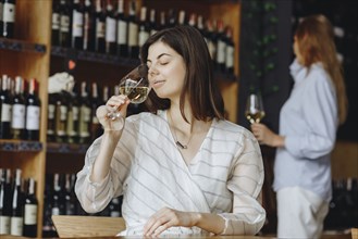 Young woman smelling white wine