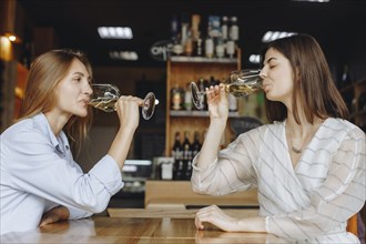 Young women drinking white wine