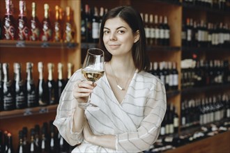 Young woman holding glass of white wine