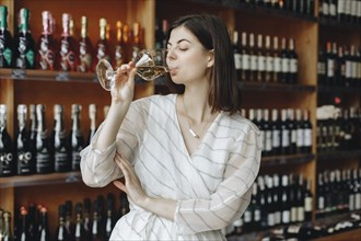 Young woman drinking white wine