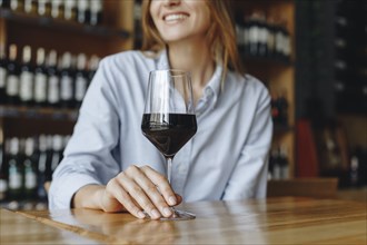 Woman holding glass of red wine