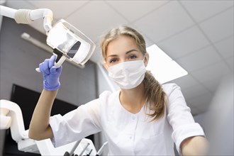 Patient point of view of dental assistant holding light
