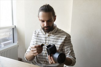 Young man holding camera and SD card