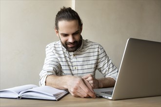 Young businessman putting USB stick into laptop