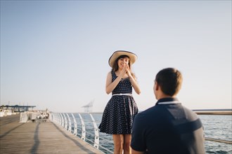 Man proposing to woman on pier