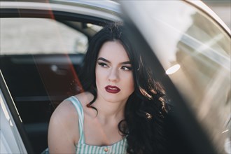 Young woman wearing red lipstick sitting in car