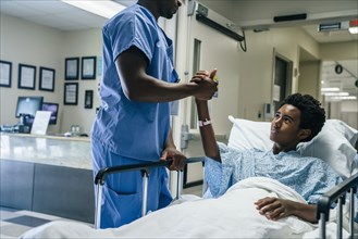 Nurse holding teenage patient's hand
