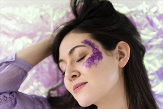 Woman with purple glitter on cheek