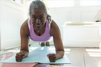 Smiling mature woman doing yoga