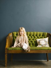 Girl sitting on green sofa