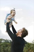 Man lifting baby daughter