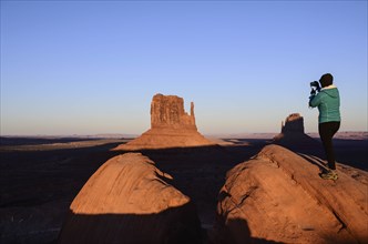Woman photographing butte in Monument Valley, Arizona, USA