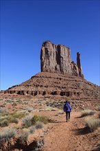 Woman hiking by butte in Monument Valley, Arizona, USA