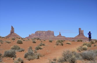 Woman wearing backpack by buttes in Monument Valley, Arizona, USA