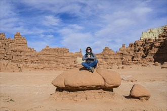 Woman meditating on rock in Goblin Valley State Park, Utah, USA