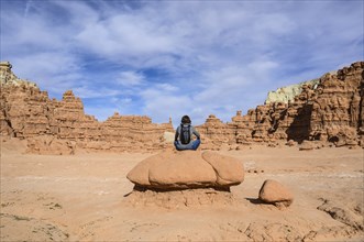 Woman sitting on rock in Goblin Valley State Park, Utah, USA