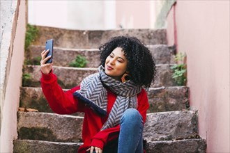 Young woman taking selfie on steps