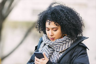 Young woman text messaging on smart phone