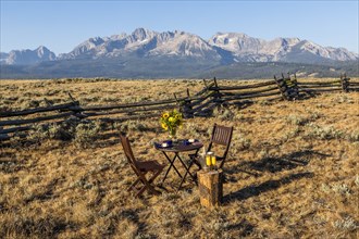 Dining table and chairs in field by mountain in Stanley, Idaho