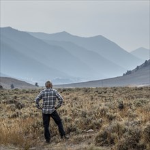 Senior man standing in field by mountains in Sun Valley, Idaho, USA