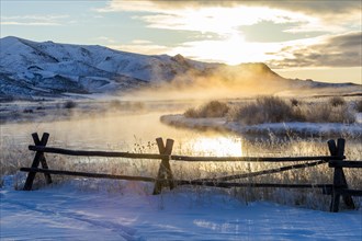 Fence by river at sunrise in Picabo, Idaho