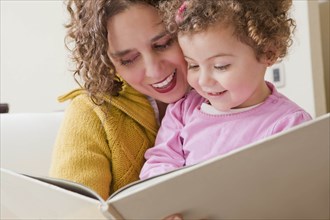 Mother and daughter reading picture book