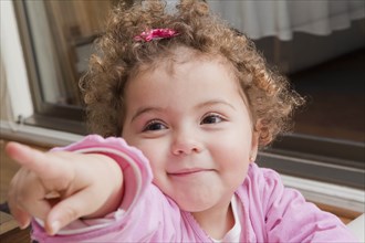 Girl with curly hair pointing